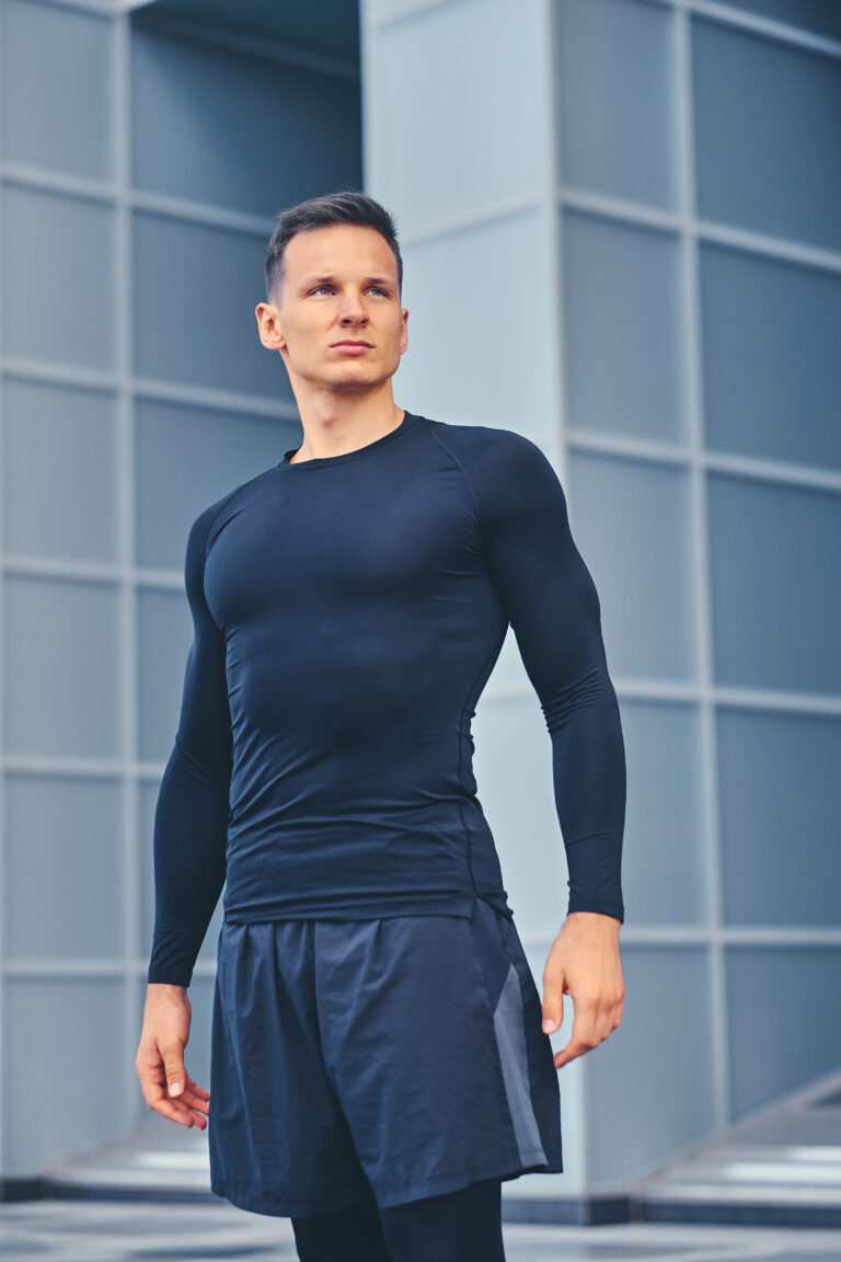 a man in a black sportswear over modern building background.